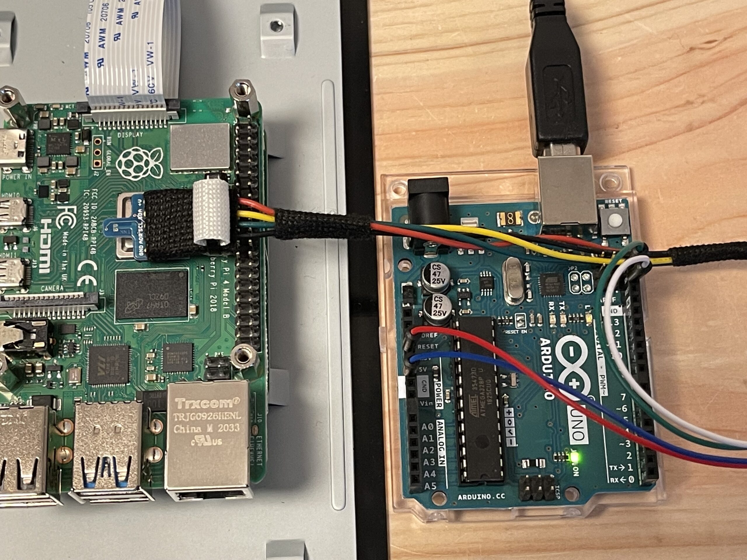 SHT31温度センサの基板両面に被覆チューブ（白いパイプ状の筒）をクッション材として挟んで固定